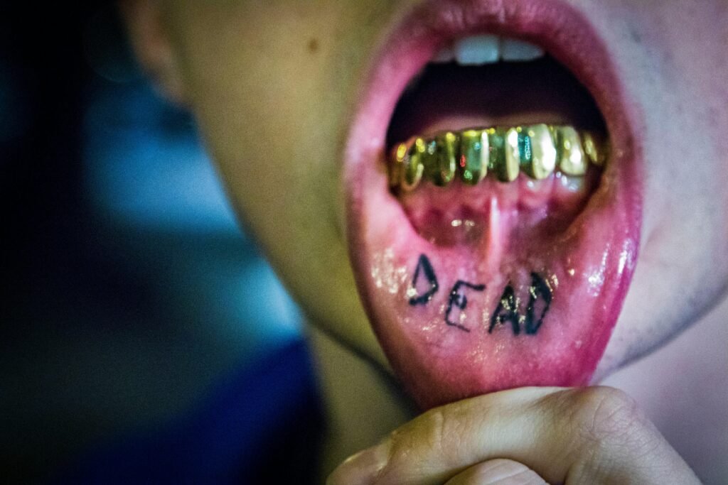 Intense close-up of gold grills and a tattooed tongue, emphasizing bold fashion in Seattle.